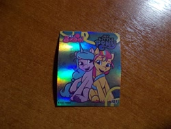 Size: 1024x768 | Tagged: safe, imported from derpibooru, izzy moonbow, sunny starscout, earth pony, unicorn, 2d, berry, food, fruit, g5, horn, indonesian, looking at each other, looking at someone, merchandise, official, photo, shiny, sitting, smiling, sticker, together, together forever