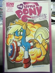Size: 768x1024 | Tagged: safe, artist:thom zahler, idw, imported from derpibooru, applejack, earth pony, pony, spoiler:comic13, 2014, applejack's hat, captain america, clothes, comic cover, commission, cosplay, costume, cover, cover art, cowboy hat, crossover, explosion, female, hat, irl, mare, marvel, my little pony logo, new york comic con, new york comic con 2014, open mouth, open smile, photo, raised hoof, raised leg, shield, signature, smiling, solo, tail, traditional art