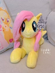 Size: 2552x3402 | Tagged: safe, imported from derpibooru, applejack, fluttershy, pegasus, pony, couch, double dove, irl, looking at you, lying down, merchandise, official, photo, pillow, plushie, pony plushie, reesee, smiling, smiling at you, text