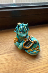 Size: 1290x1939 | Tagged: safe, artist:fomminator, imported from derpibooru, lyra heartstrings, pony, unicorn, autumn leaves, craft, figurine, horn, irl, leaf, leaves, lying down, lyre, musical instrument, papier-mache, photo, prone, solo