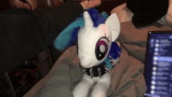 Size: 1280x720 | Tagged: safe, derpibooru exclusive, imported from derpibooru, vinyl scratch, pony, unicorn, animated, choker, horn, irl, lying down, patting, photo, plushie, spiked choker, video, webm, wiggle